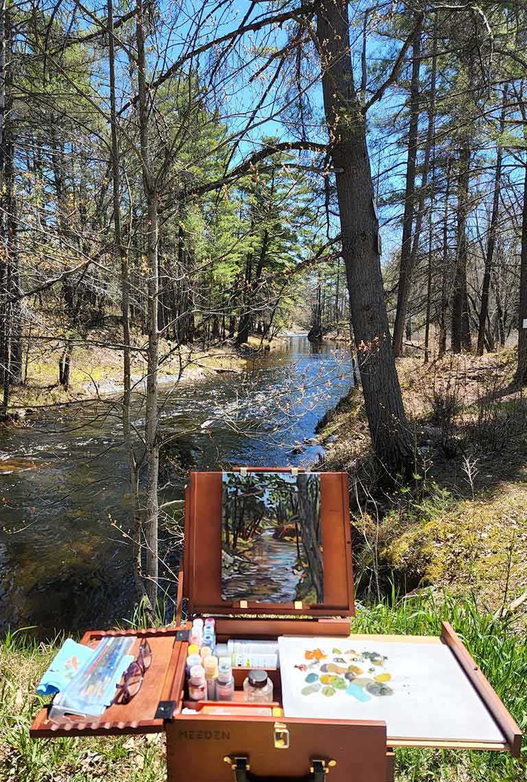 registration-form-sidebar Studio 201 artist's easel, paints and canvas overlooking a woodland stream in early Spring